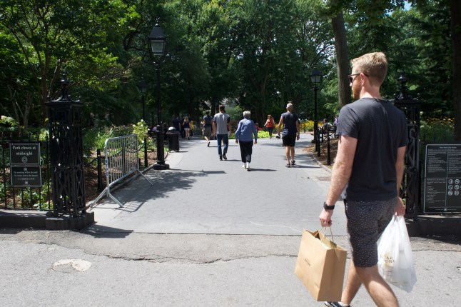 A shopper enters the park on his way elsewhere.