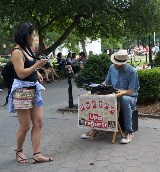 A fellow photographer checks out a man selling instant poetry for $10. 