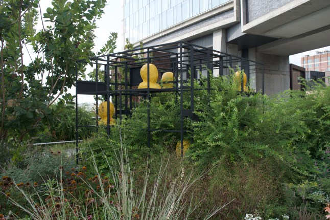 One of the first pieces you'll see are these busts painted in traffic-sign yellow and seated on dark metal shelves.
